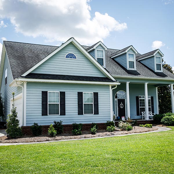Front View of blue house with siding in the suburbs