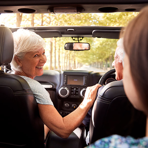 Grandparents And Grandchildren Driving In Open Top Car